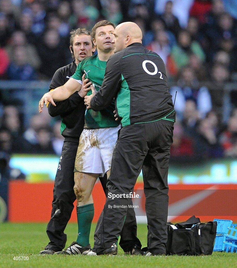 27 February 2010; Ireland captain Brian O'Driscoll is held up by team physio Cameron Steele and team doctor Dr. Eanna Falvey after falling to the ground twice with suspected concussion during the game. RBS Six Nations Rugby Championship, England v Ireland, Twickenham Stadium, Twickenham, London, England. Picture credit: Brendan Moran / SPORTSFILE