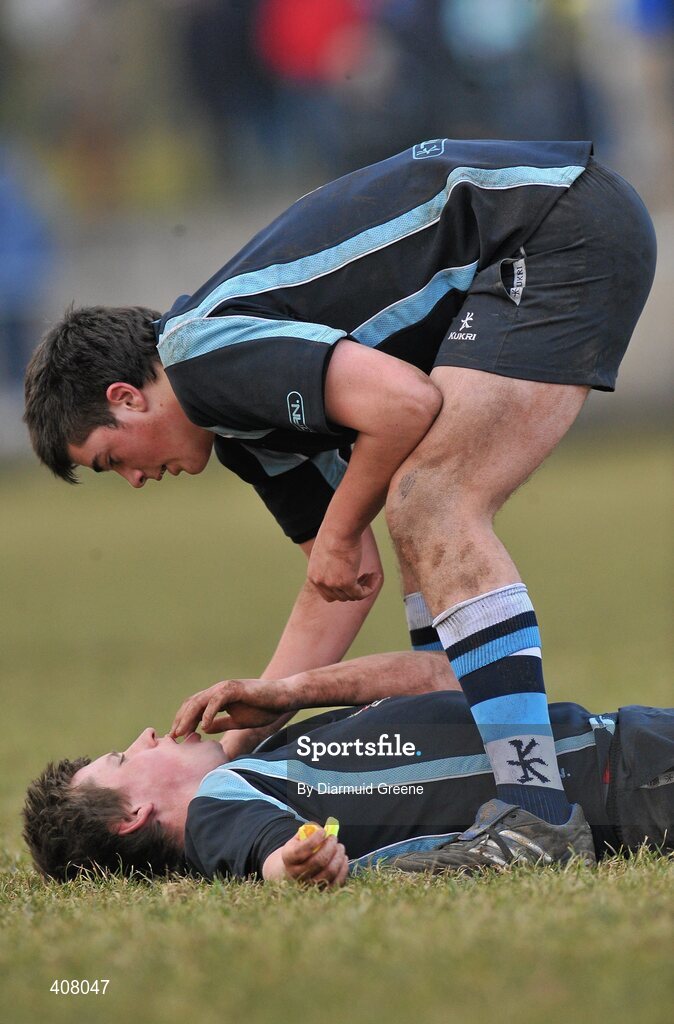 3 March 2010; Castletroy's Alex De Souza assists team-mate Michael Dooley as he lies on the pitch during the game. Avonmore Munster Rugby Schools Senior Cup Semi-Final, Rockwell v Castletroy College, Clanwilliam Park, Tipperary Town, Tipperary. Picture credit: Diarmuid Greene / SPORTSFILE