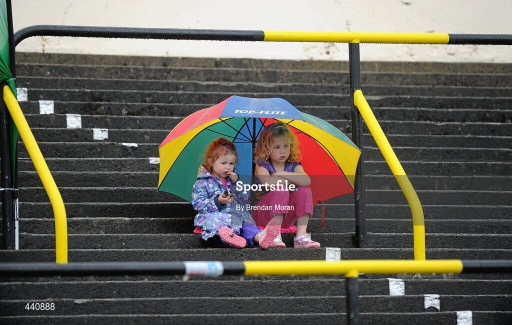 10 July 2010; Athletics fans Caoimhe, left, age 2 and Adrienne Gallen, age 5, from Donegal, shelter from the rain while supporting Mary McLoone of Tir Cholaill AC in the Women's Long Jump during the Woodie's DIY AAI Senior Track & Field Championships. Morton Stadium, Santry, Dublin. Picture credit: Brendan Moran / SPORTSFILE