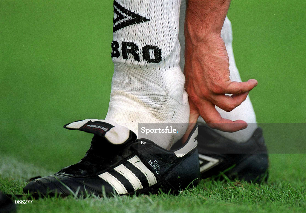 26 June 2001; A player puts on his boots. Soccer. Picture credit; David Maher / SPORTSFILE