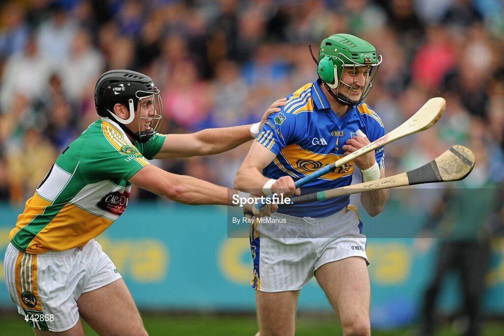 18 July 2010; Declan Fanning, Tipperary, prepares to clear under pressure from Offaly corner-forward Shane Dooley. Fanning's helmet has been adapted to offer extra protection to his right ear after a recent injury. GAA Hurling All-Ireland Senior Championship Phase 3, Tipperary v Offaly, O'Moore Park, Portlaoise, Co. Laois. Picture credit: Ray McManus / SPORTSFILE