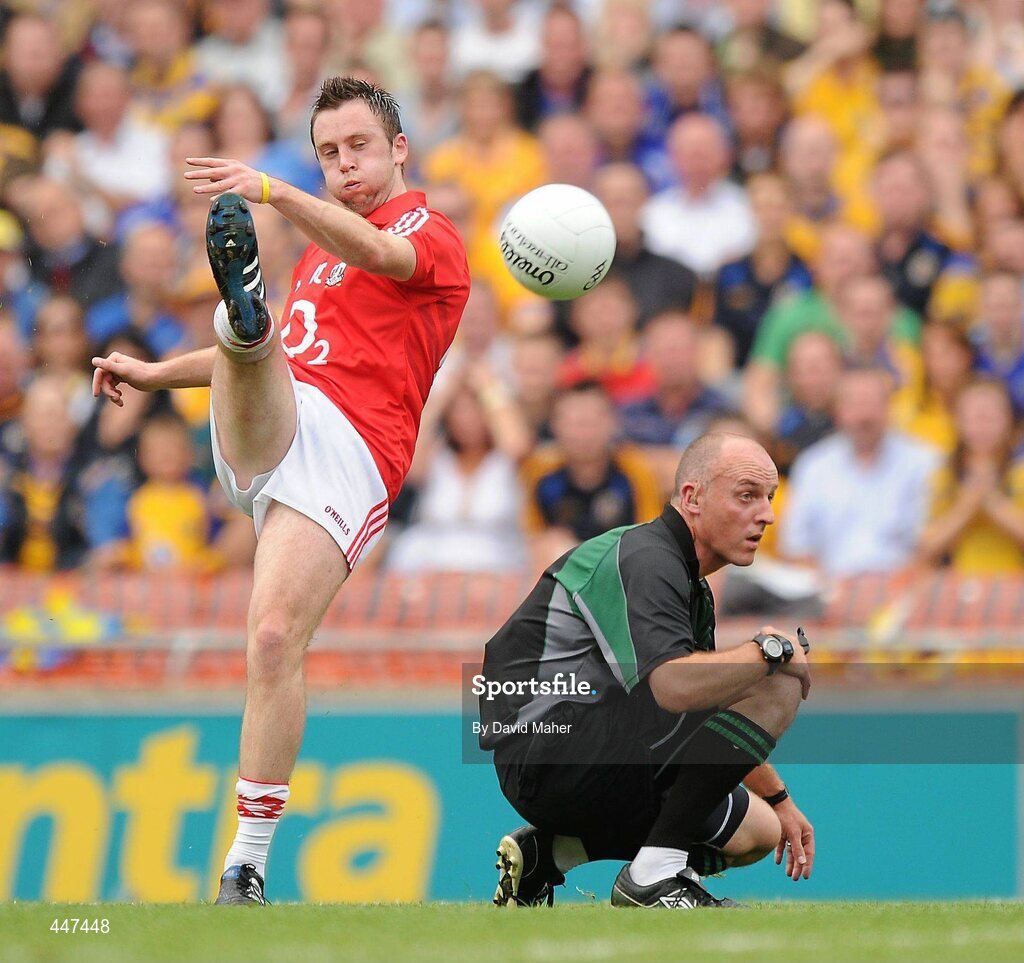1 August 2010; Referee Cormac Reilly has to crouch down as Paul Kerrigan, Cork, takes a kick at goal. GAA Football All-Ireland Senior Championship Quarter-Final, Roscommon v Cork, Croke Park, Dublin. Picture credit: David Maher / SPORTSFILE