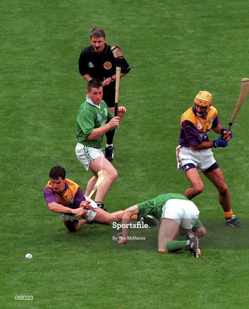 1 September 1996; Wexford pair Adrian Fenlon, left, and George O'Connor in action against Limerick pair Mike Houlihan, standing, and Sean O'Neill during the Guinness All-Ireland Senior Hurling Championship Final match between Wexford and Limerick at Croke Park in Dublin. Photo by Ray McManus/Sportsfile
