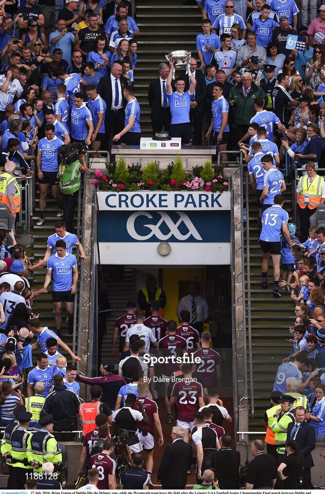 17 July 2016; Brian Fenton of Dublin lifts the Delaney cup, while the Westmeath team leave the field after the Leinster GAA Football Senior Championship Final match between Dublin and Westmeath at Croke Park in Dubin. Photo by Daire Brennan/Sportsfile