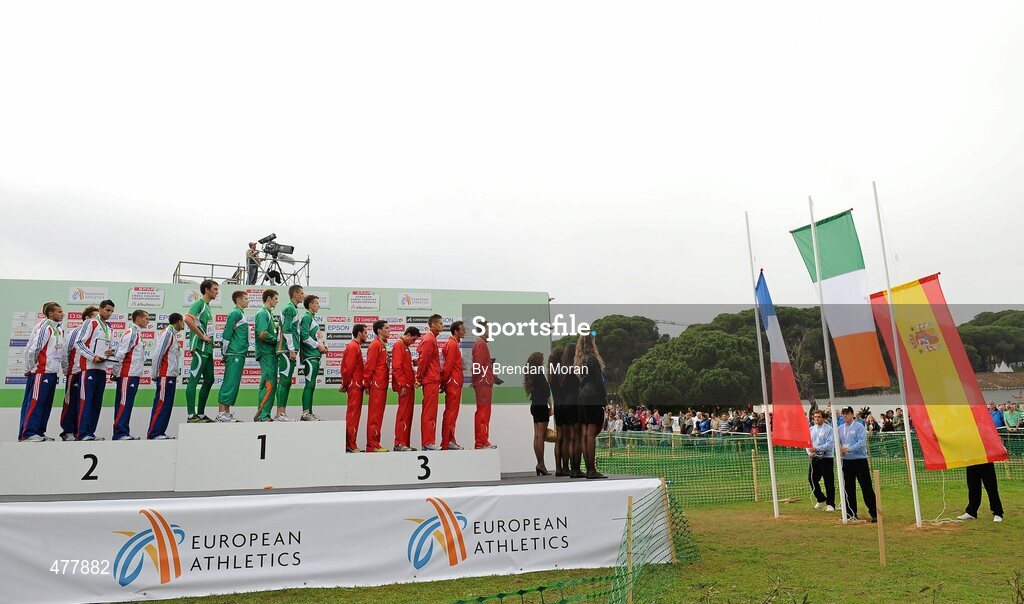 12 December 2010; The Ireland U23 men's team, having been presented with their gold medals, stand for the playing of Amhrann na bhFiann as the Irish tricolour is raised during the presentation of the team medals for the Men's U23 race. 17th SPAR European Cross Country Championships, Albufeira, Portugal. Picture credit: Brendan Moran / SPORTSFILE