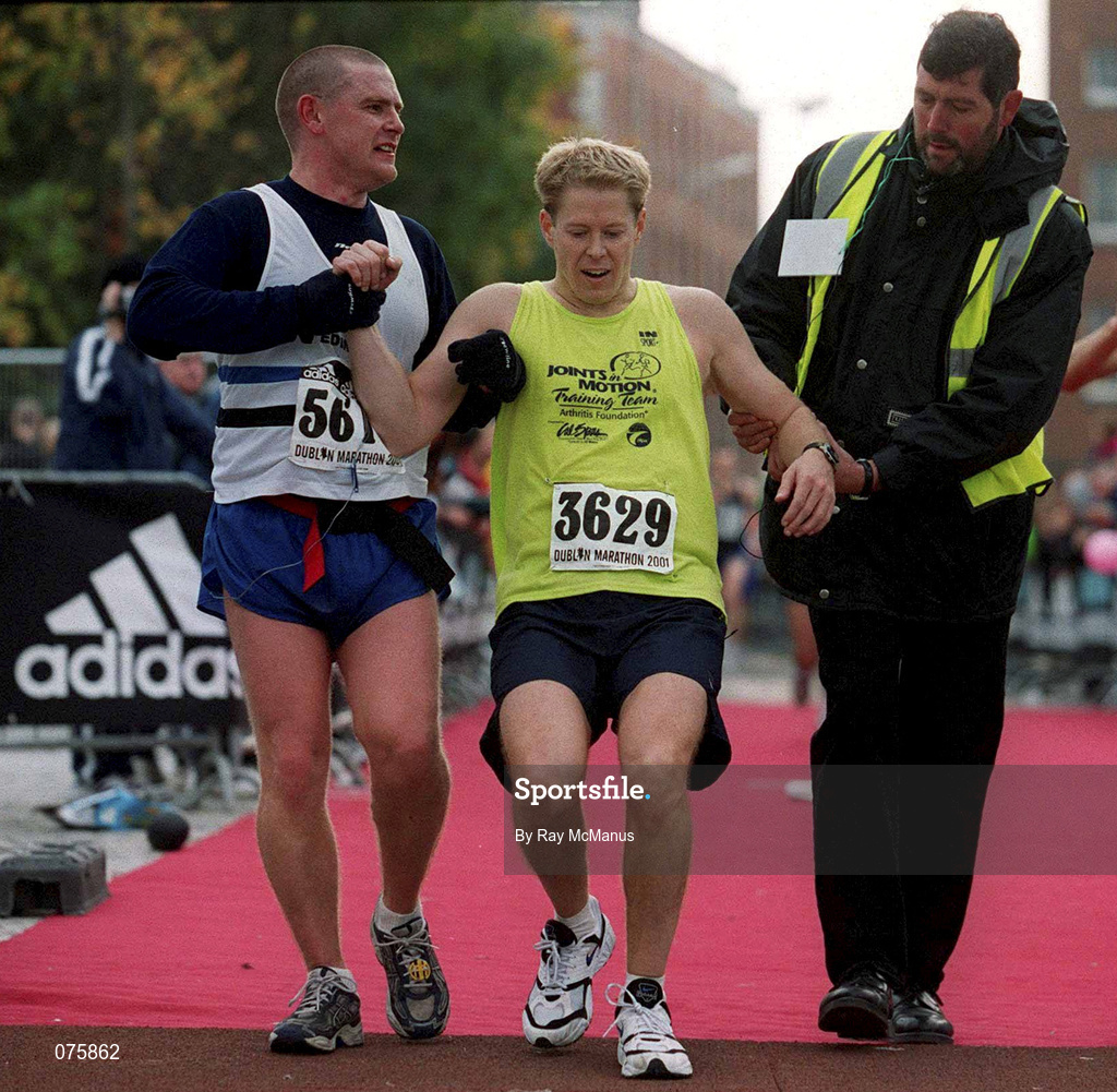 29 October 2001; Paul Irving, American, is assisted across the finish line. adidas Dublin Marathon 2001, Dublin. Photo by Ray McManus/Sportsfile
