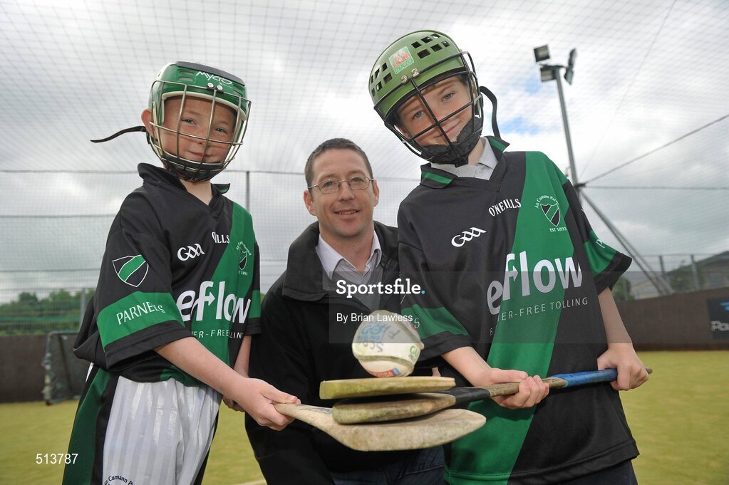 10 May 2011; Dublin National Hurling League winner Liam Ryan marks the beginning of 'Camán Let’s Play', a hurling initiative organised by Parnell’s GAA Club to promote hurling and encourage participation among local Dublin schools. With over 220 children, ranging from 7yrs – 12yrs due to take part, the competition will be based on a round robin series of games, supported by eFlow and at no expense to the participating schools. Pictured at the launch is Liam Ryan with pupils of Scoil Fhursa, Kilmore West, Adam Ives, age 9, from Coolock, right, and Dylan Doherty, age 9, from Coolock. Launch of 'Camán Let’s Play', supported by eFlow, Astro Park, Coolock, Dublin. Picture credit: Brian Lawless / SPORTSFILE