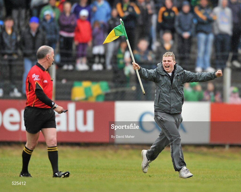 12 June 2011; A spectator runs onto the pitch, holding the corner flag, as he runs past referee Pat Enaney during the game. Connacht GAA Football Senior Championship Semi-Final, Leitrim v Roscommon, Páirc Seán Mac Diarmada, Carrick-on-Shannon, Co. Leitrim. Picture credit: David Maher / SPORTSFILE