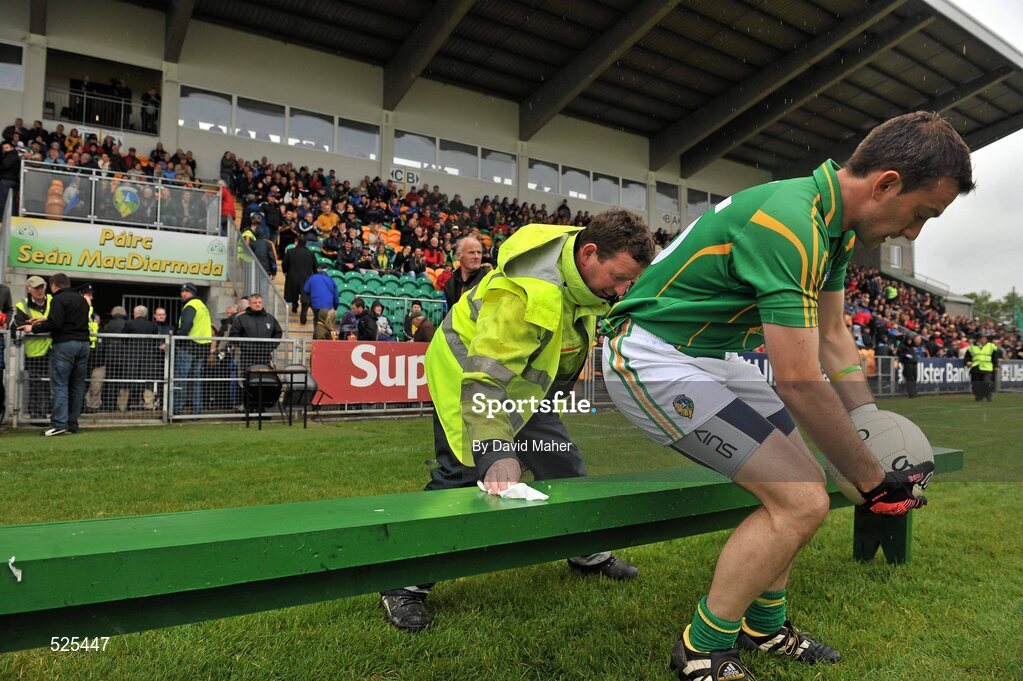 12 June 2011; Local groundsman Michael Doherty clears the team bench of rain water as the Leitrim captain James Glancy prepares to sit down for the official team photograph. Connacht GAA Football Senior Championship Semi-Final, Leitrim v Roscommon, Páirc Seán Mac Diarmada, Carrick-on-Shannon, Co. Leitrim. Picture credit: David Maher / SPORTSFILE