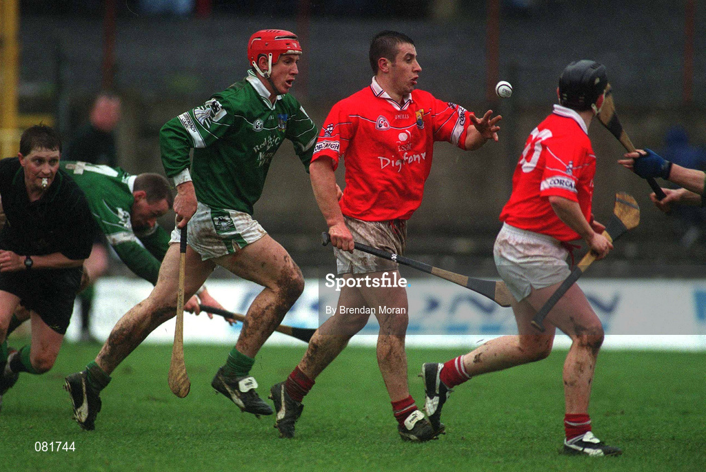25 February 2002; Derek Barrett of Cork handpasses to team-mate Pat Ryan, despite the attentions of Ollie Moran of Limerick during the Allianz National Hurling League Division 1B Round 1 match between Limerick and Cork at the Gaelic Grounds in Limerick. Photo by Brendan Moran/Sportsfile