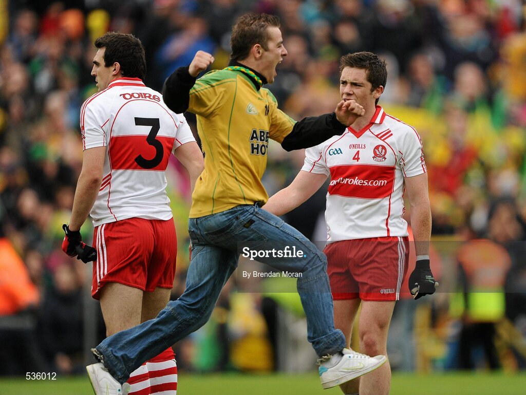 17 July 2011; A celebrating Donegal supporter runs past Derry players Kevin McGuckin, 3, and Dermot McBride, at the final whistle. Ulster GAA Football Senior Championship Final, Derry v Donegal, St Tiernach's Park, Clones, Co. Monaghan. Picture credit: Brendan Moran / SPORTSFILE