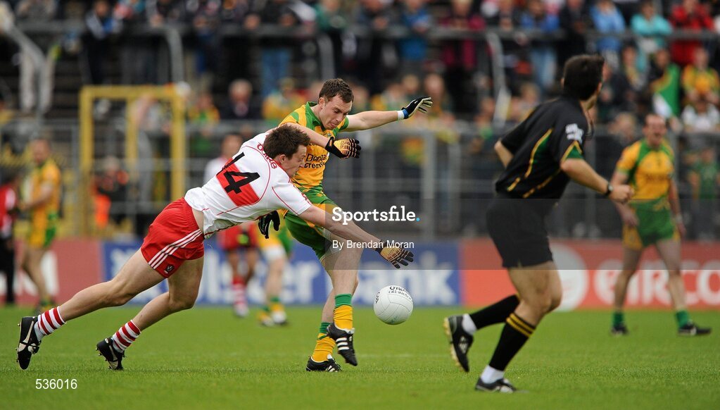 17 July 2011; Martin McElhinny, Donegal, kicks downfield despite the best efforts of James Kielt, Derry, watched by referee Maurice Deegan. Ulster GAA Football Senior Championship Final, Derry v Donegal, St Tiernach's Park, Clones, Co. Monaghan. Picture credit: Brendan Moran / SPORTSFILE