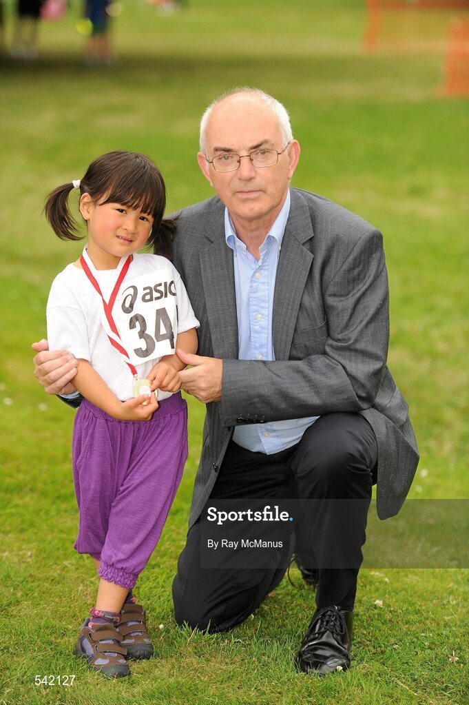 31 July 2011; Three year old Victorine Tám Thomas, from Clondalkin, Dublin, with Liam Hennessy, President of Athletics Ireland, after finishing the Athletics Ireland Family Fitness Festival at Farmleigh. Phoenix Park, Dublin. Picture credit: Ray McManus / SPORTSFILE
