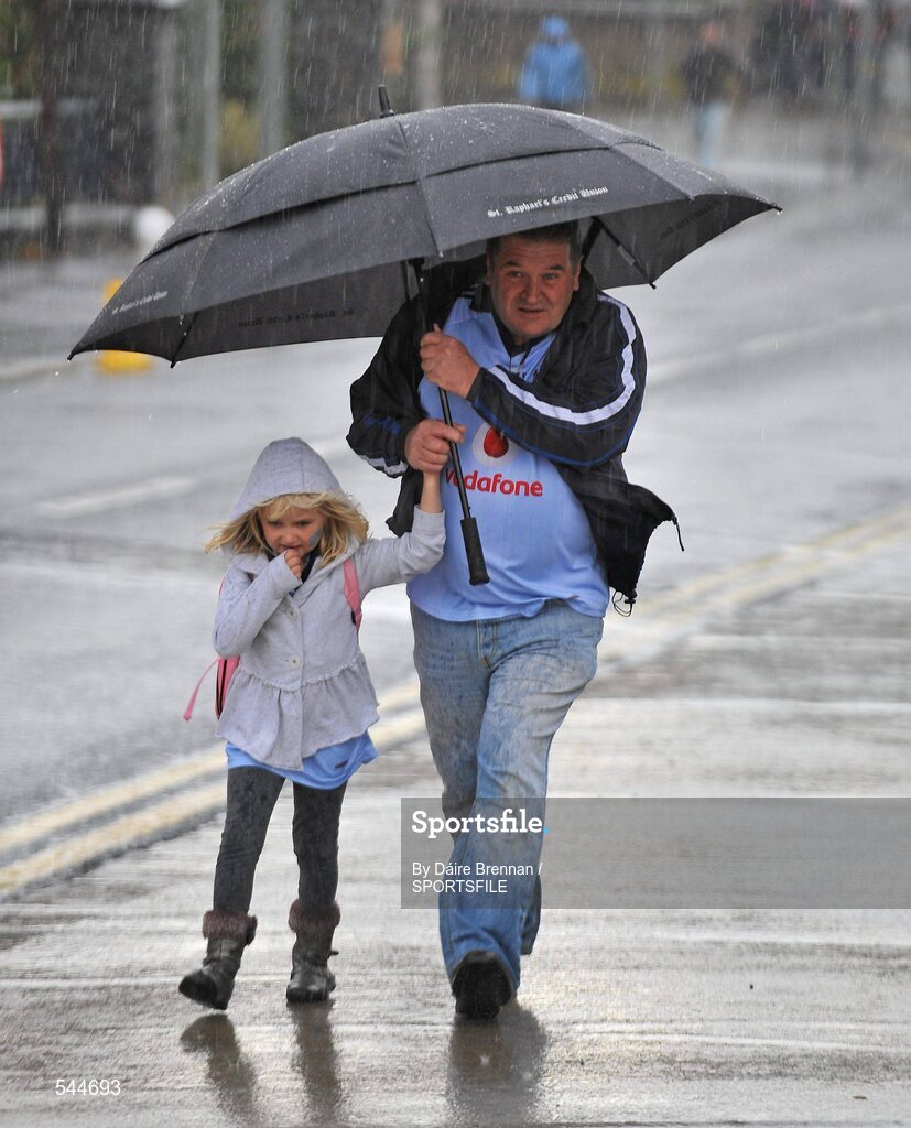 6 August 2011; Pat McGurk, from Swords, Co. Dublin, shelters under an umbrella with his daughter Kate, aged 6, on Jones' Road before the GAA Football All-Ireland Senior Championship Quarter-Final, Dublin v Tyrone, Croke Park, Dublin. Picture credit: Daire Brennan / SPORTSFILE