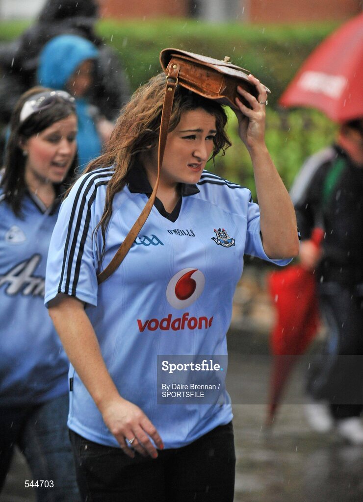 6 August 2011; A Dublin supporter uses her bag to shelter from the rain on her way to the GAA Football All-Ireland Senior Championship Quarter-Final, Dublin v Tyrone, Croke Park, Dublin. Picture credit: Daire Brennan / SPORTSFILE