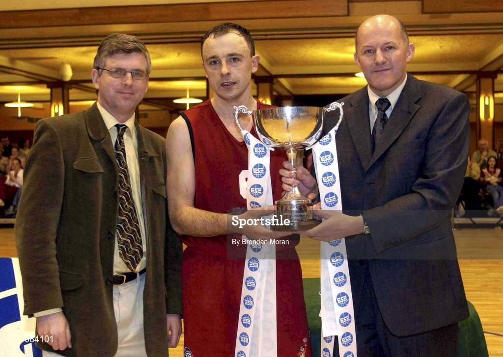 24 March 2002; Tralee captain John Teahan is presented with the trophy by President of the IBA, Tony Colgan, right, following the ESB Men's National Championships Final between Frosties Tigers Tralee and Dart Killester at the National Exhibition Centre in Killarney, Kerry. Photo by Brendan Moran/Sportsfile