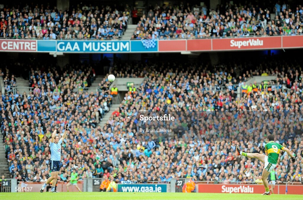 18 September 2011; Kerry's Bryan Sheehan kicks a point as Dublin's Denis Bastick looks on. GAA Football All-Ireland Senior Championship Final, Kerry v Dublin, Croke Park, Dublin. Picture credit: Brian Lawless / SPORTSFILE