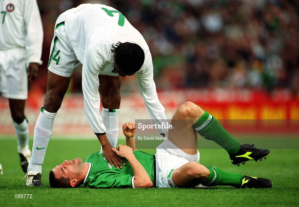 16 May 2002; Nigeria's Nwanko Kanu attempts to help Republic of Ireland's Roy Keane to his feet following a challenge on him during the International Friendly match between Republic of Ireland and Nigeria at Lansdowne Road in Dublin. Photo by David Maher/Sportsfile