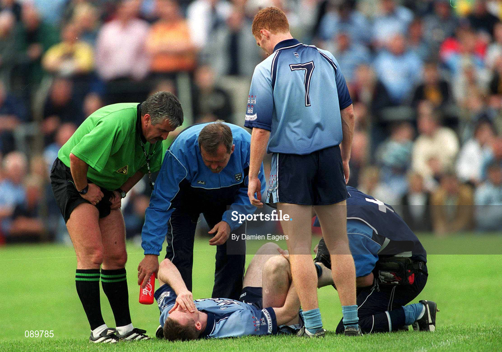 1 June 2002; Coman Goggins lies injured on the ground as his team-mate Peadar Andrews and referee Brian Crowe look on during the Bank of Ireland Leinster Senior Football Championship Quarter-Final match between Wexford and Dublin at Dr. Cullen Park in Carlow. Photo by Damien Eagers/Sportsfile