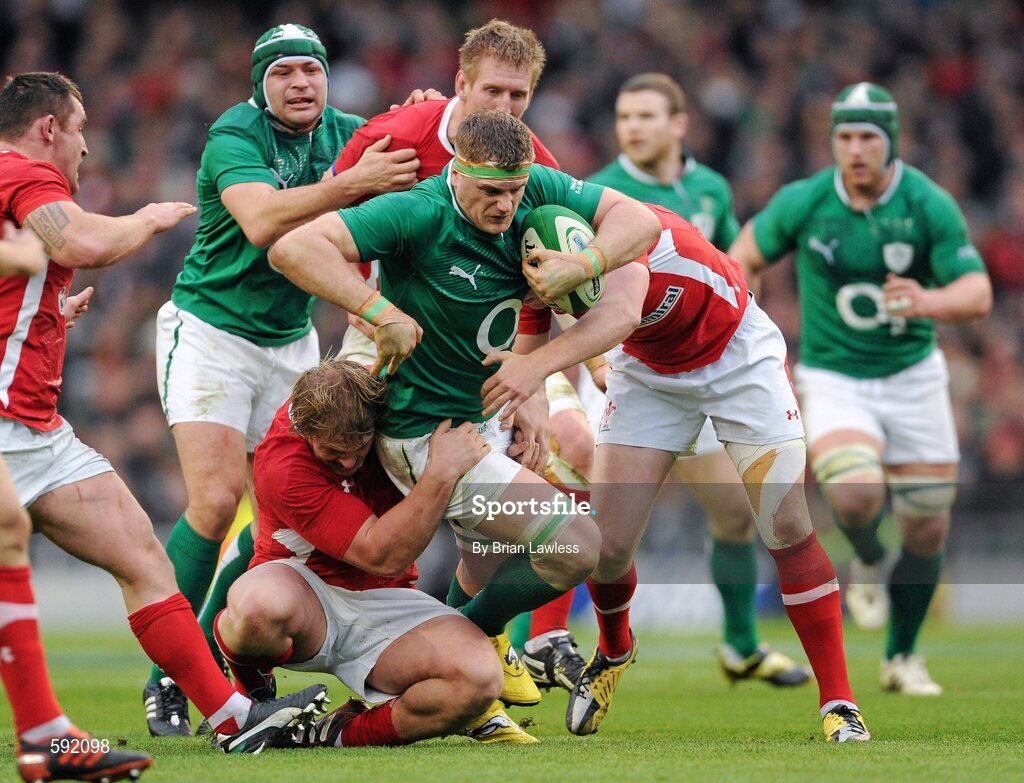 5 February 2012; Jamie Heaslip, Ireland, with support from team mate Rory Best, is tackled by Rhys Gill, left, and Rhys Priestland, Wales. RBS Six Nations Rugby Championship, Ireland v Wales, Aviva Stadium, Lansdowne Road, Dublin. Picture credit: Brian Lawless / SPORTSFILE