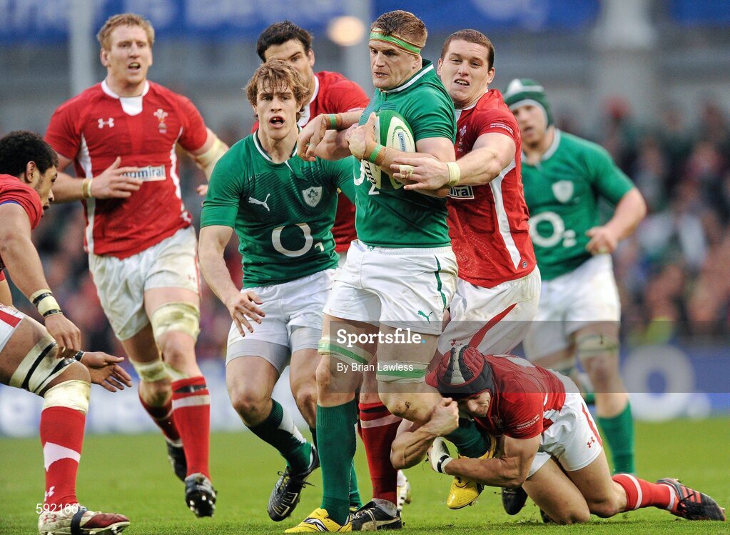 5 February 2012; Jamie Heaslip, Ireland, is tackled by Leigh Halfpenny and Ian Evans, behind, Wales. RBS Six Nations Rugby Championship, Ireland v Wales, Aviva Stadium, Lansdowne Road, Dublin. Picture credit: Brian Lawless / SPORTSFILE
