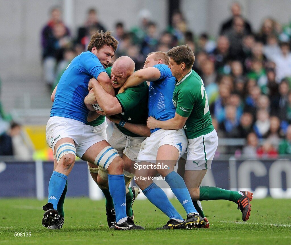 25 February 2012; Paul O'Connell, Ireland, supporterd by team mate Ronan O'Gara is tackled by Antonio Pavanello, left, and Leonardo Ghiraldini, Italy. RBS Six Nations Rugby Championship, Ireland v Italy, Aviva Stadium, Lansdowne Road, Dublin. Picture credit: Ray McManus / SPORTSFILE