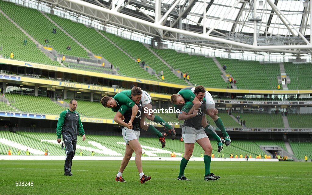 25 February 2012; Ireland players Ronan O'Gara and Donnacha Ryan carry team-mates Eoin Reddan and Tom Court as the substitutes go through their after match warm-down routine under the direction of strength and conditioning coach Jason Cowman. RBS Six Nations Rugby Championship, Ireland v Italy, Aviva Stadium, Lansdowne Road, Dublin. Picture credit: Brendan Moran / SPORTSFILE