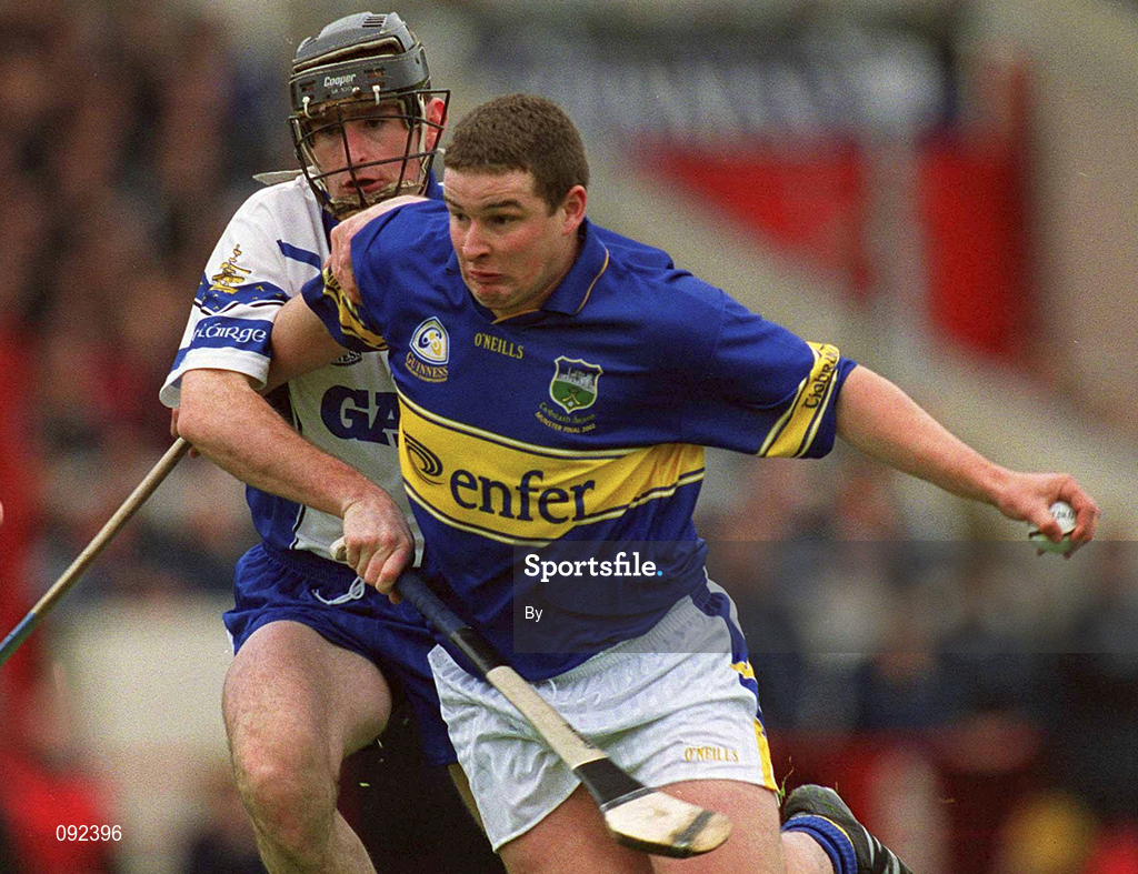 30 June 2002; John Carroll, Tipperary, in action against Waterford's Tom Feeney. Waterford v Tipperary, Guinness Munster Hurling Final, Pairc Ui Chaoimh, Cork. Picture credit; Ray McManus / SPORTSFILE