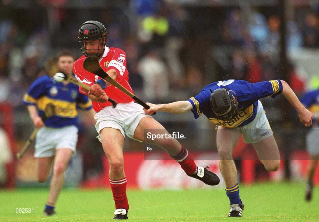 30 June 2002; Michael Naughton, Cork, in action against Tipperary's Conor O'Mahony. Tipperary v Cork, Munster Minor Hurling Final, Pairc Ui Chaoimh, Cork. Picture credit; Ray McManus / SPORTSFILE