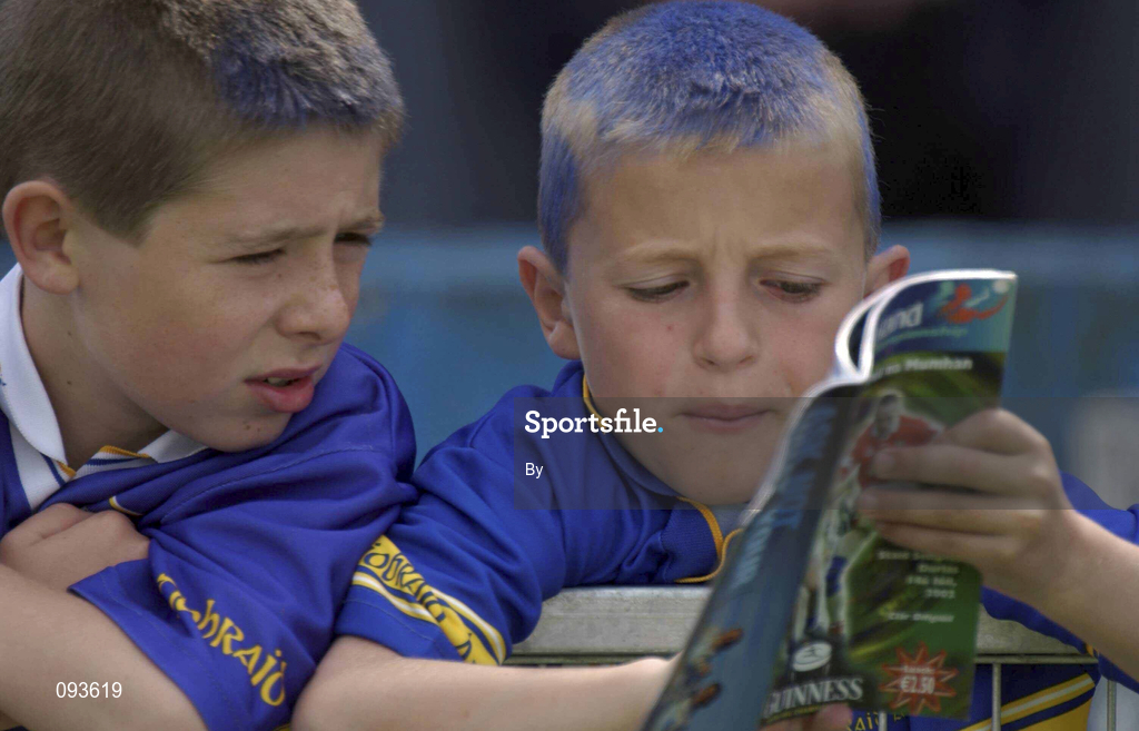 14 July 2002; Two young Tipperary fans check out the match programme during the game. Bank of Ireland Munster Football Final, Cork v Tipperary, Semple Stadium, Thurles, Co. Tipperary. Picture credit; Brendan Moran / SPORTSFILE