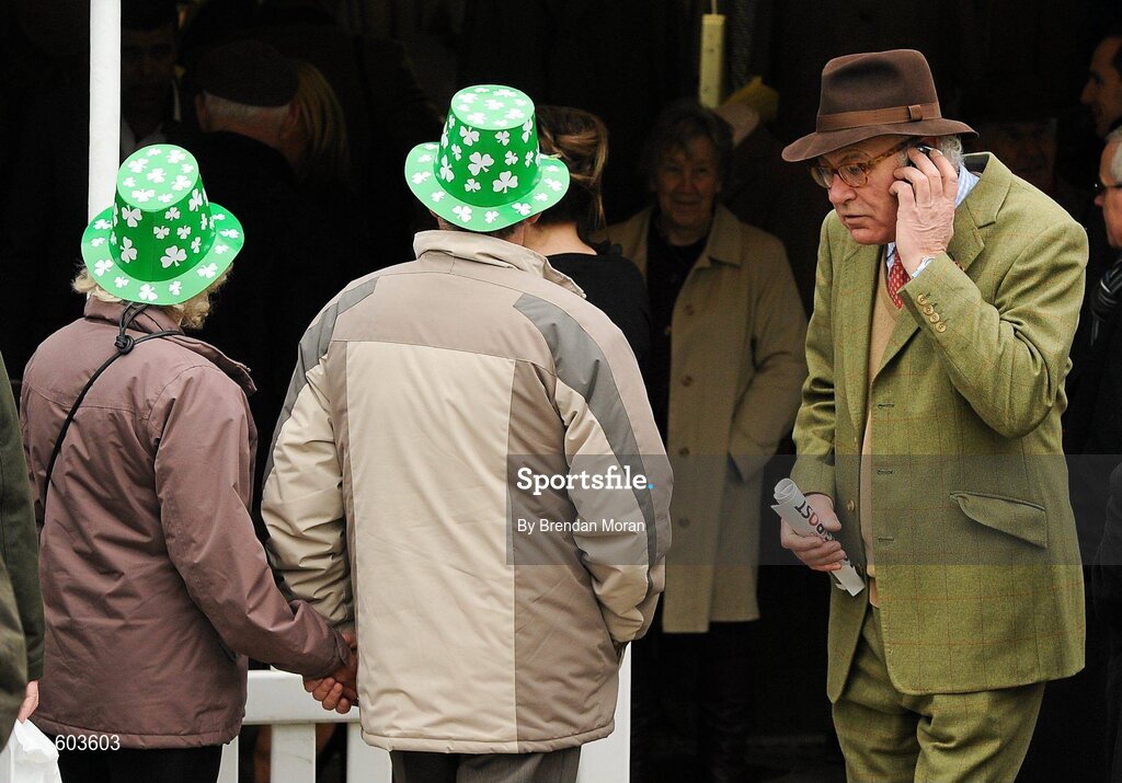 14 March 2012; A couple wearing plastic shamrock hats in attendance during Ladies Day at the Cheltenham Festival. Cheltenham Racing Festival, Prestbury Park, Cheltenham, England. Picture credit: Brendan Moran / SPORTSFILE