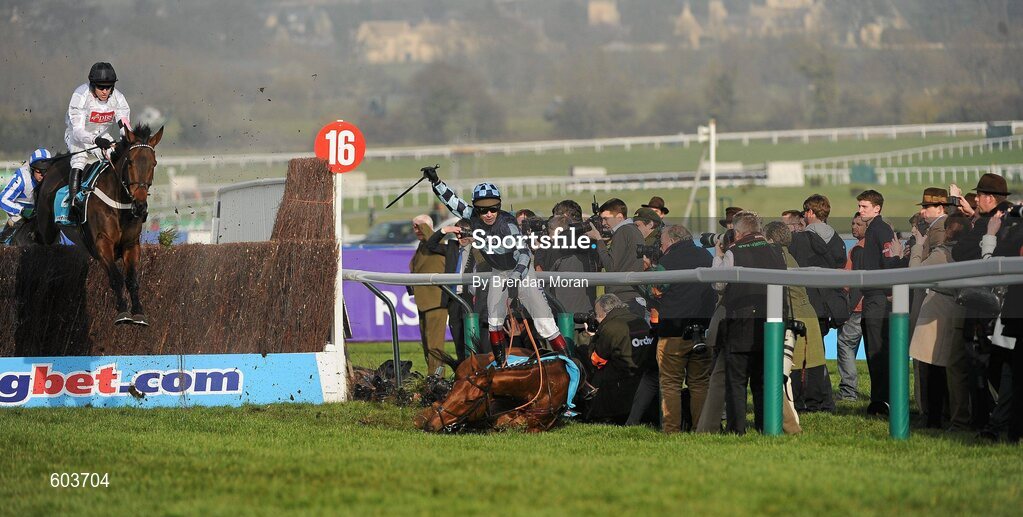 14 March 2012; Jockey Richard Johnson is unseated by his mount Wishful Thinking as they crash into a number of photographers and trackside personnel as the eventual winner Finian's Rainbow, left, with Barry Geraghty up, clear 'the last first time round' during the sportingbet.com Queen Mother Champion Steeple Chase. Cheltenham Racing Festival, Prestbury Park, Cheltenham, England. Picture credit: Brendan Moran / SPORTSFILE