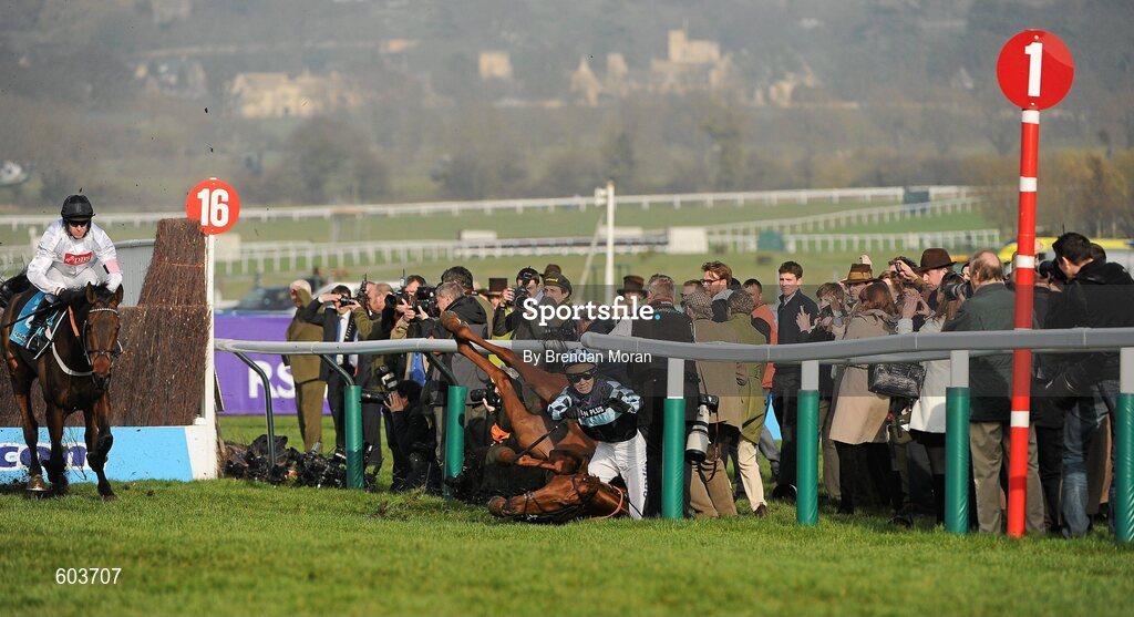 14 March 2012; Jockey Richard Johnson is unseated by his mount Wishful Thinking as they crash into a number of photographers and trackside personnel as the eventual winner Finian's Rainbow, left, with Barry Geraghty up, clear 'the last first time round' during the sportingbet.com Queen Mother Champion Steeple Chase. Cheltenham Racing Festival, Prestbury Park, Cheltenham, England. Picture credit: Brendan Moran / SPORTSFILE