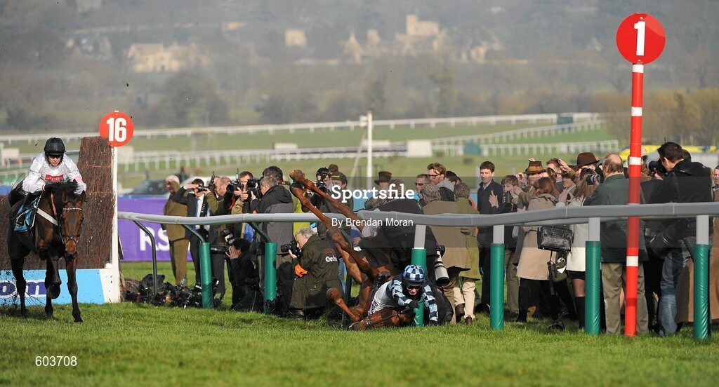 14 March 2012; Jockey Richard Johnson is unseated by his mount Wishful Thinking as they crash into a number of photographers and trackside personnel as the eventual winner Finian's Rainbow, left, with Barry Geraghty up, clear 'the last first time round' during the sportingbet.com Queen Mother Champion Steeple Chase. Cheltenham Racing Festival, Prestbury Park, Cheltenham, England. Picture credit: Brendan Moran / SPORTSFILE