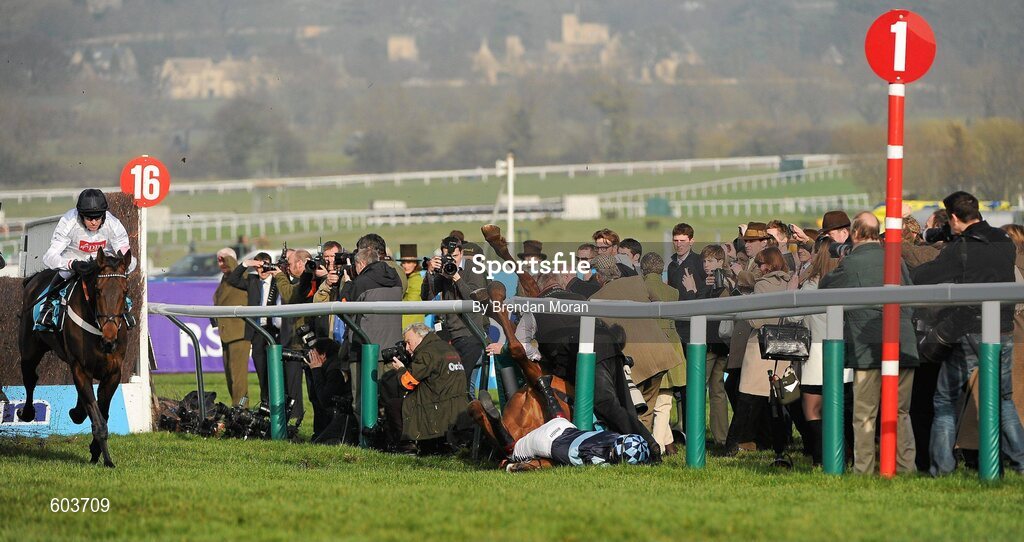 14 March 2012; Jockey Richard Johnson is unseated by his mount Wishful Thinking as they crash into a number of photographers and trackside personnel as the eventual winner Finian's Rainbow, left, with Barry Geraghty up, clear 'the last first time round' during the sportingbet.com Queen Mother Champion Steeple Chase. Cheltenham Racing Festival, Prestbury Park, Cheltenham, England. Picture credit: Brendan Moran / SPORTSFILE