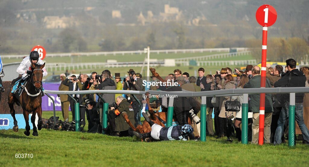 14 March 2012; Jockey Richard Johnson is unseated by his mount Wishful Thinking as they crash into a number of photographers and trackside personnel as the eventual winner Finian's Rainbow, left, with Barry Geraghty up, clear 'the last first time round' during the sportingbet.com Queen Mother Champion Steeple Chase. Cheltenham Racing Festival, Prestbury Park, Cheltenham, England. Picture credit: Brendan Moran / SPORTSFILE