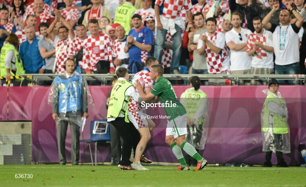 10 June 2012; Jonathan Walters, Republic of Ireland, helps a steward apprehend a Croatian pitch invader during the final minutes of the game. EURO2012, Group C, Republic of Ireland v Croatia, Municipal Stadium Poznan, Poznan, Poland. Picture credit: David Maher / SPORTSFILE