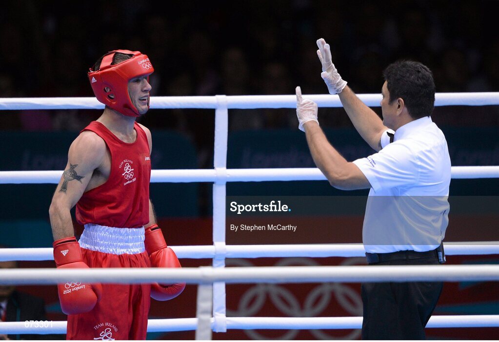 11 August 2012; John Joe Nevin, Ireland, receives a count from the referee during the third round of his men's bantam 56kg final contest. London 2012 Olympic Games, Boxing, South Arena 2, ExCeL Arena, Royal Victoria Dock, London, England. Picture credit: Stephen McCarthy / SPORTSFILE