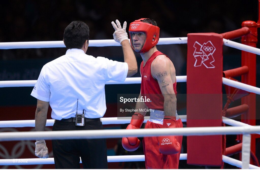 11 August 2012; John Joe Nevin, Ireland, receives a count from the referee during the third round of his men's bantam 56kg final contest. London 2012 Olympic Games, Boxing, South Arena 2, ExCeL Arena, Royal Victoria Dock, London, England. Picture credit: Stephen McCarthy / SPORTSFILE