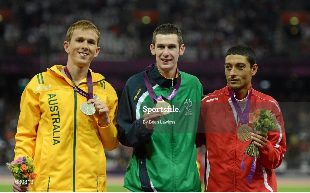 3 September 2012; Ireland's Michael McKillop, from Newtownabbey, Co. Antrim, celebrates after he was presented with his gold medal, alongside silver medallist Brad Scott, left, Australia, and bronze medallist Mohamed Charmi, right, following his victory in the men's 1500m - T37 final in a time of 4.08:11. London 2012 Paralympic Games, Athletics, Olympic Stadium, Olympic Park, Stratford, London, England. Picture credit: Brian Lawless / SPORTSFILE