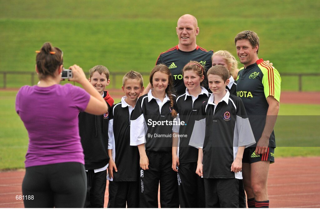 5 September 2012; Munster's Paul O'Connell and Ronan O'Gara pose for a photograph with pupils from Coláiste Chiaráin, Croom, Co. Limerick, after squad training ahead of their Celtic League, Round 2, match against Benetton Treviso on Friday. Munster Rugby Squad Training, University of Limerick, Limerick. Picture credit: Diarmuid Greene / SPORTSFILE