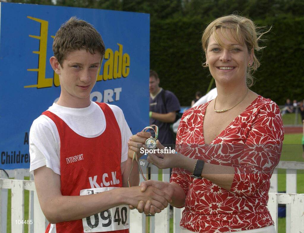 27th July 2002; Conor McGrath, K.C.K. Waterford, is presented with the Silver Medal by Rosemary Lyster, Marketing Manager, Lucozade Sport after the  U.15 high Jump event at the Lucozade Sport AAI Juvenile Track & Field Championship of Ireland 2002, Tullamore Harriers Stadium, Tullamore, Co. Offaly. Athletics. Picture credit; Ray McManus / SPORTSFILE *EDI*