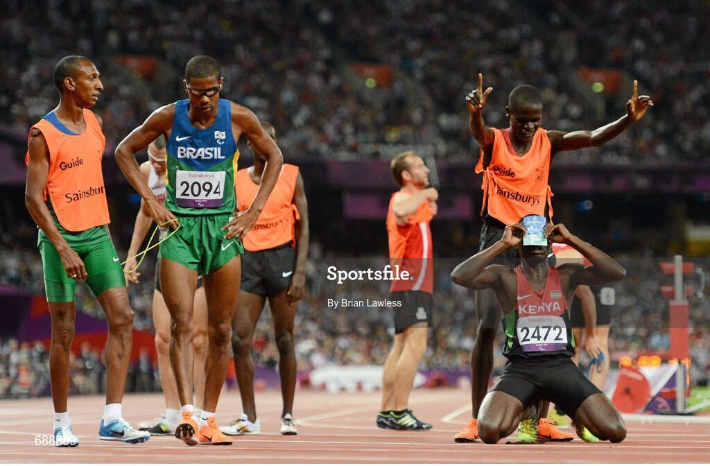 3 September 2012; Samwel Mushai Kimani, Kenya, celebrates with his guide James Boit, after they won the Men's 1500m - T11 in a World record time of 3:58.37, by displaying a church flyer for Revival House. London 2012 Paralympic Games, Athletics, Olympic Stadium, Olympic Park, Stratford, London, England. Picture credit: Brian Lawless / SPORTSFILE