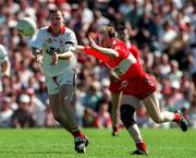 29 June 1997; Chris Lawn of Tyrone gets a pass away despite the attentions of Seamus Downey of Derry during the Ulster GAA Football Senior Championship Semi-Final match between Tyrone and Derry at St. Tiernach's Park in Clones, Monaghan. Photo by David Maher/Sportsfile