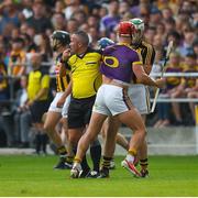 9 June 2018; Referee James McGrath watches play as he stands between Lee Chin of Wexford and Martin Keoghan of Kilkenny, before issuing them both with yellow cards, during the Leinster GAA Hurling Senior Championship Round 5 match between Kilkenny and Wexford at Nowlan Park in Kilkenny. Photo by Ray McManus/Sportsfile