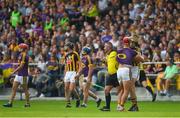 9 June 2018; Referee James McGrath watches play as he stands between Lee Chin of Wexford and Martin Keoghan of Kilkenny, before issuing them both with yellow cards, during the Leinster GAA Hurling Senior Championship Round 5 match between Kilkenny and Wexford at Nowlan Park in Kilkenny. Photo by Ray McManus/Sportsfile