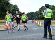 14 July 2018; A member of An Garda Siochana gives encouragement to competitors during the Irish Runner 10 Mile at Phoenix Park in Dublin. Photo by Eoin Smith/Sportsfile