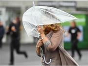 31 July 2018; A racegoer battles the wind as they arrive prior to racing at the Galway Races Summer Festival 2018, in Ballybrit, Galway. Photo by Seb Daly/Sportsfile