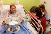 10 September 2018; Cliodhna Barrett Muprhy, age 15, from Doneraile, Cork, minds the cup while Cork camogie players sign her jersey during the All-Ireland Senior Camogie Champions visit to Our Lady's Children's Hospital in Crumlin, Dublin. Photo by Eóin Noonan/Sportsfile
