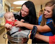 10 September 2018; Rua Buckley, age 8 months, with Cork camogie players Aishling Thompson, left, and Sarah Harrington during the All-Ireland Senior Camogie Champions visit to Our Lady's Children's Hospital in Crumlin, Dublin. Photo by Eóin Noonan/Sportsfile